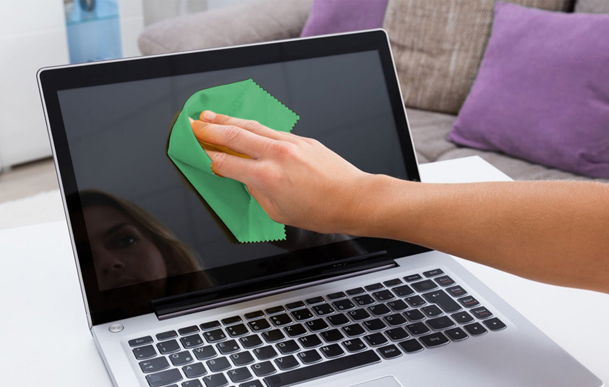 hand with green cloth clean laptop screen
